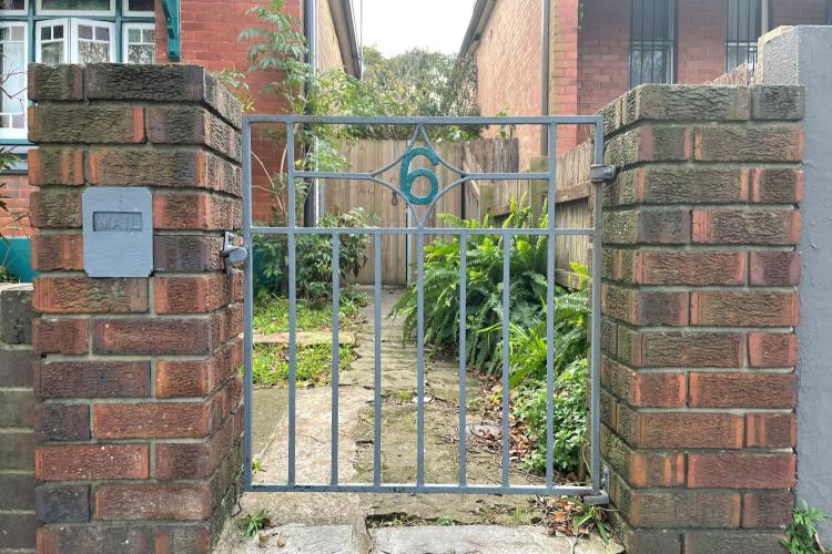 Gate, garden behind and path to house. Number 6 in metal on gate